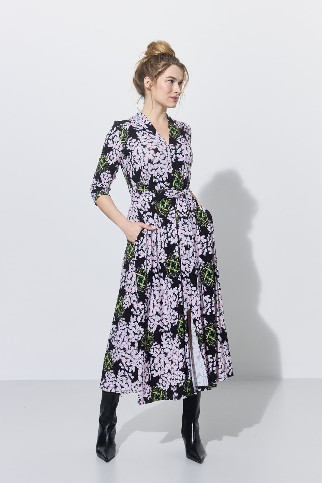 Kobieta w eleganckiej sukience midi z kwiatowym wzorem, czarnych butach i pasem, stylowa moda damska